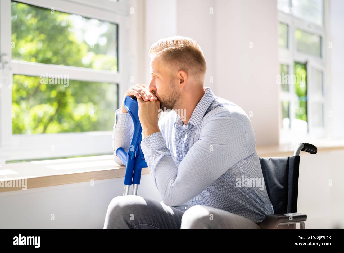 Disabled Man Difficulties. Big Accident Depression. Crutches And Wheelchair Stock Photo