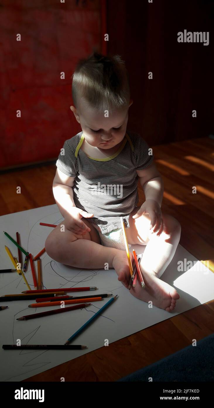 Little boy playing with pencils Stock Photo