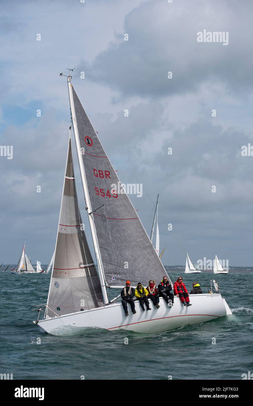 The crew of this Hunter Impala yacht seem to be enjoying their day's sailing at the Isle of Wight Sailing Club's Round The Island Race in the Solent Stock Photo