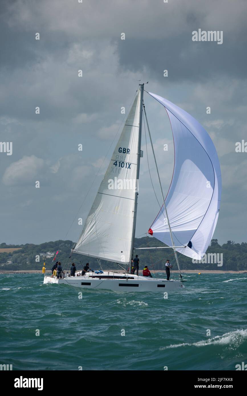 The spinnaker is out on this Sun Odyssey sailing yacht competing in the Isle of Wight Sailing Club's annual Round The Island Race in the Solent Stock Photo