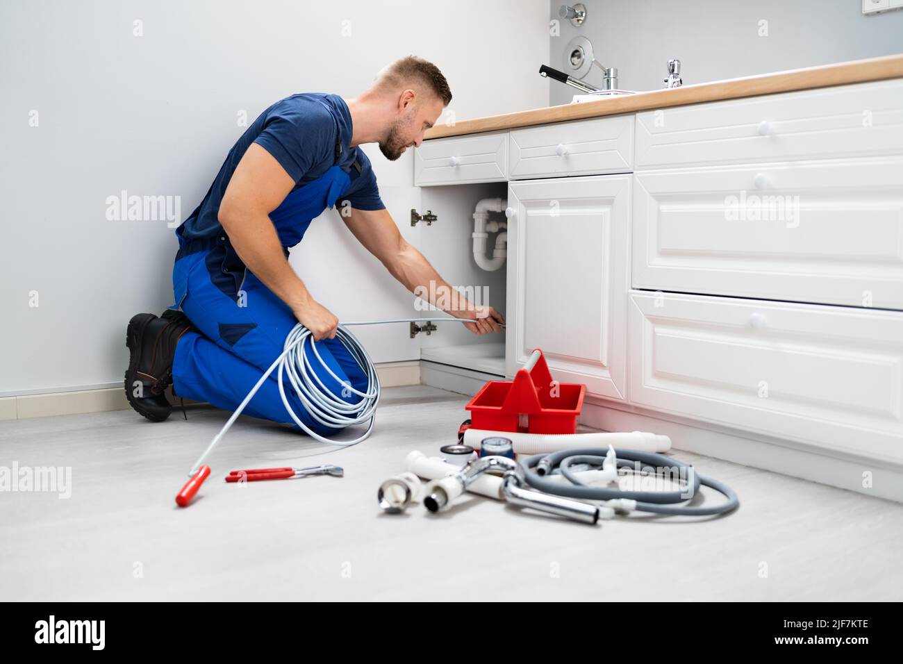 Male Plumber Cleaning Clogged Sink Pipe In Kitchen Stock Photo Alamy
