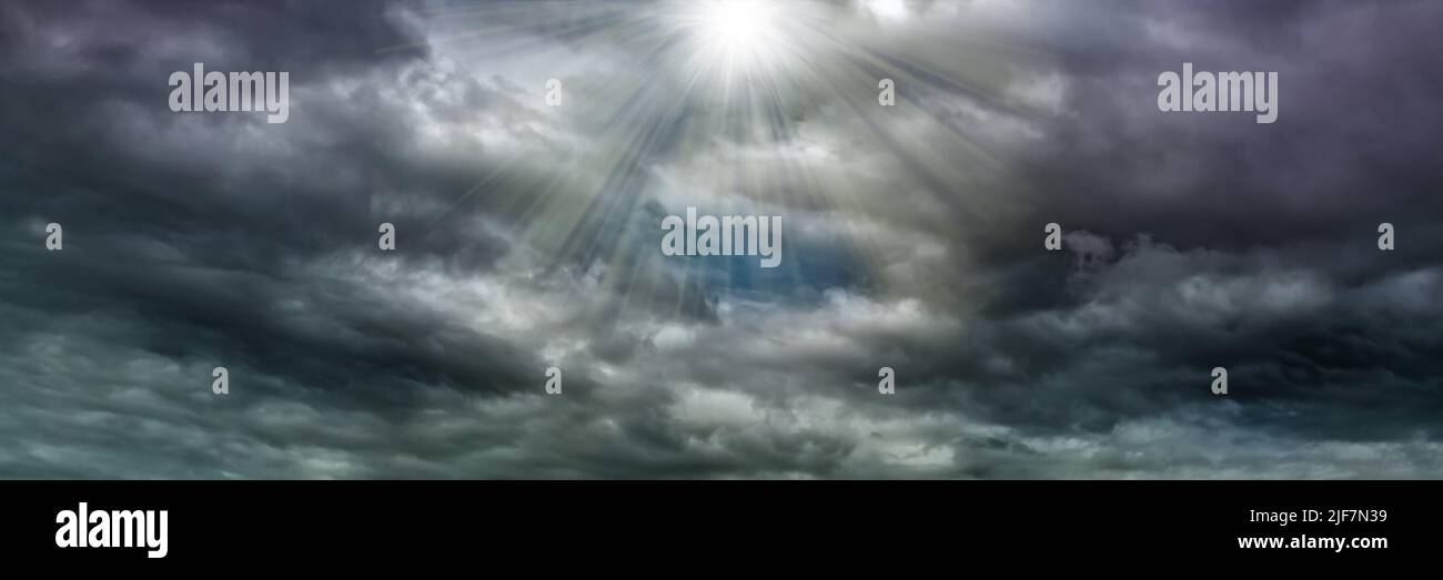 The rays of the sun break through the clouds, dramatic stormy sky, dark ...