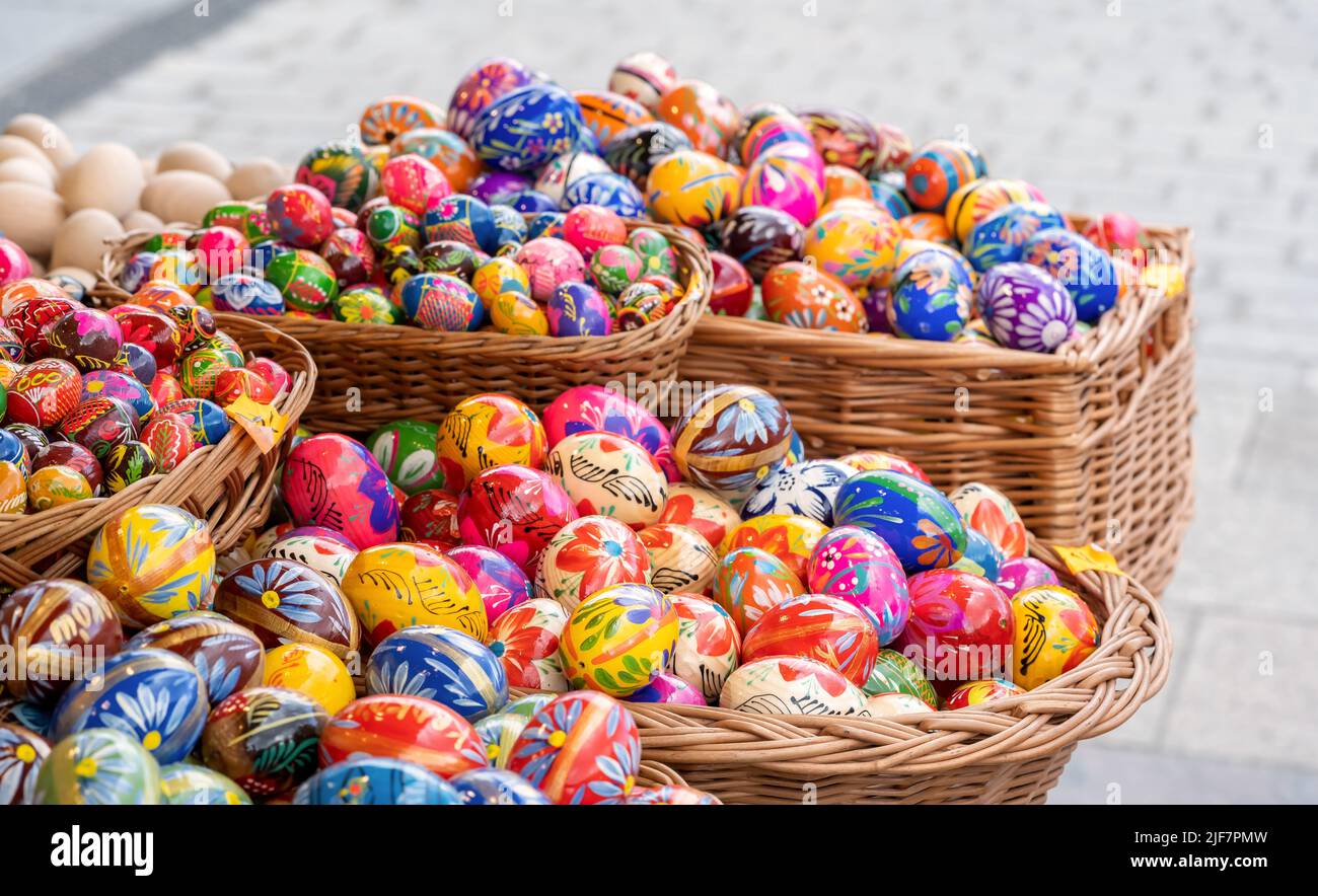 Lots of colorful handmade Easter eggs in multiple baskets, set of many traditional handcrafted Polish pisanki, festival market stall, group of objects Stock Photo