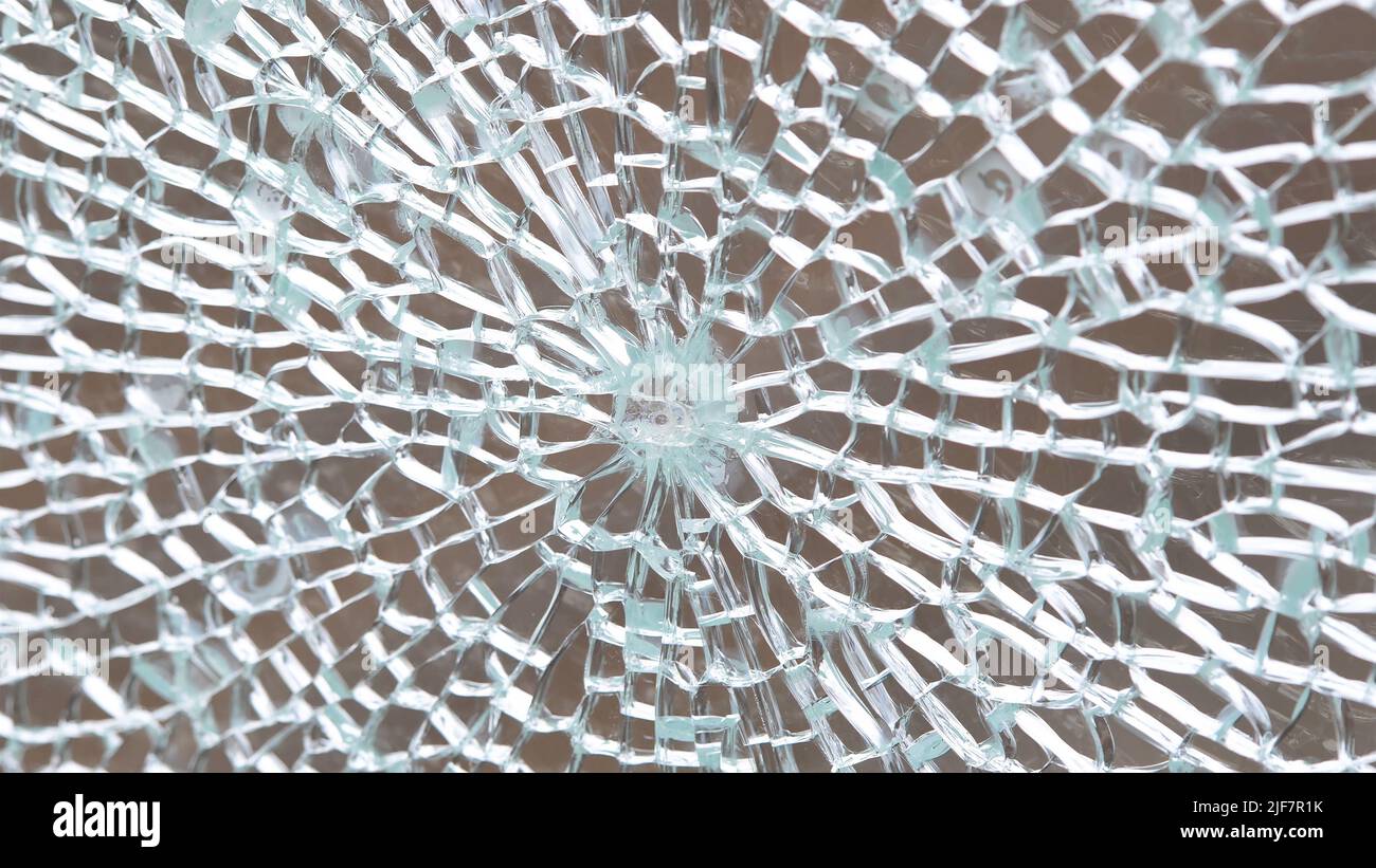 Broken tempered glass abstract background texture, shattered glass window object structure, bullet hole macro detail extreme closeup, nobody. Damaged Stock Photo