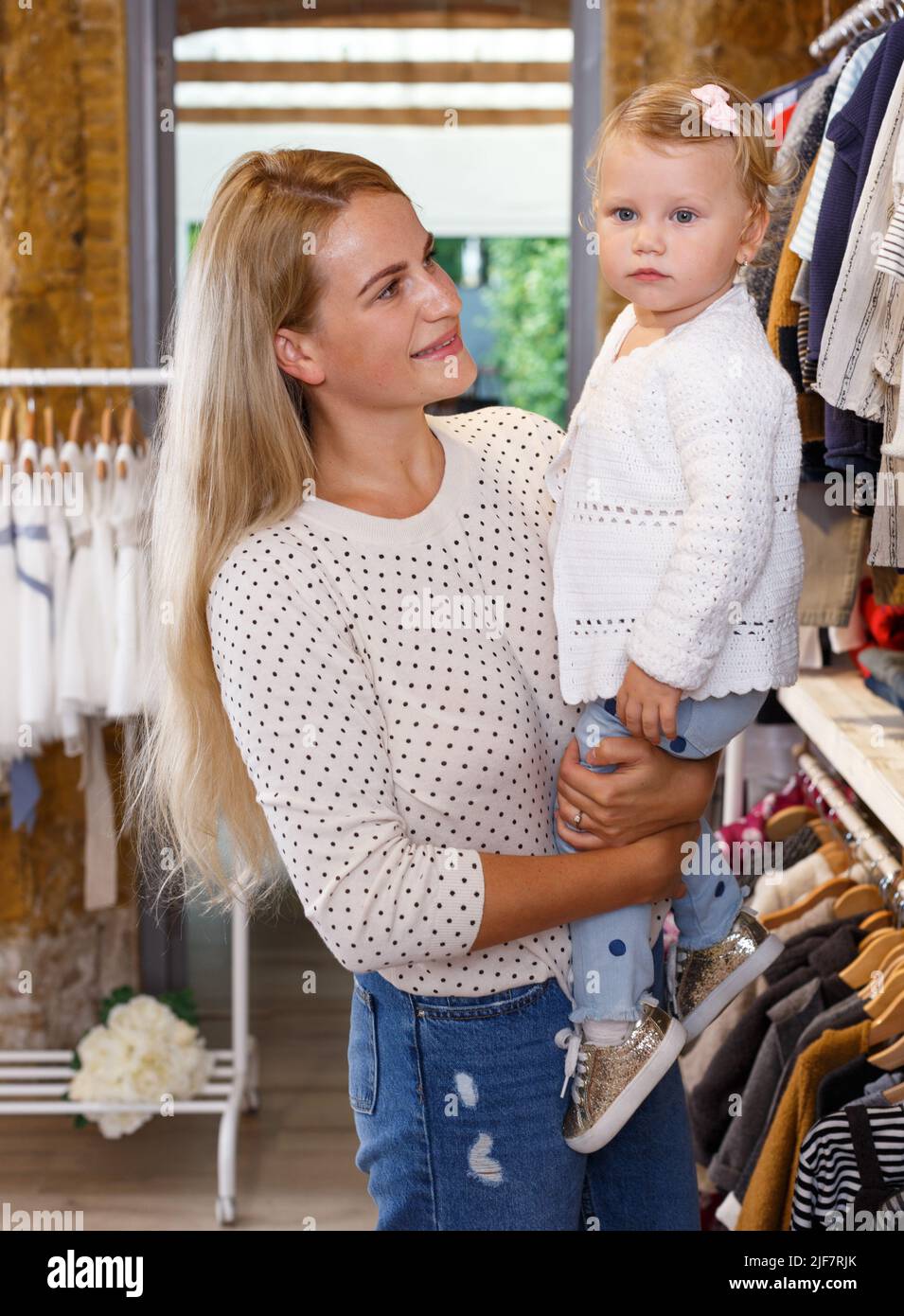 Mother and daughter choosing baby clothes Stock Photo Alamy