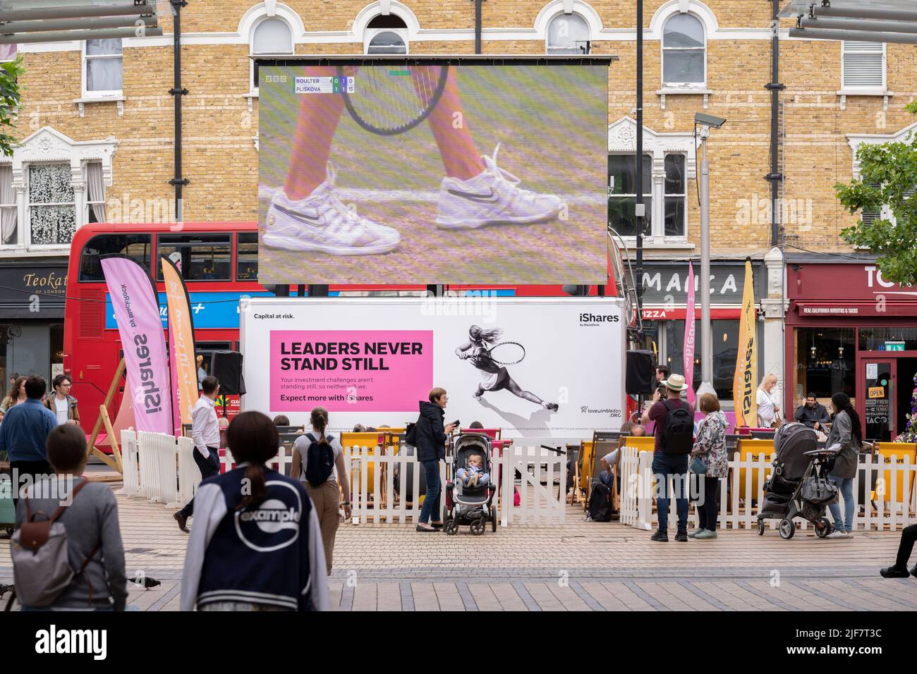 A live feed of a tennis match between Katie Boulter and Karolina Pliskova is being watched by south Londoners in Wimbledon town centre during the Lawn Tennis Association's two-week championships, on 30th June 2022, in London, England. Stock Photo