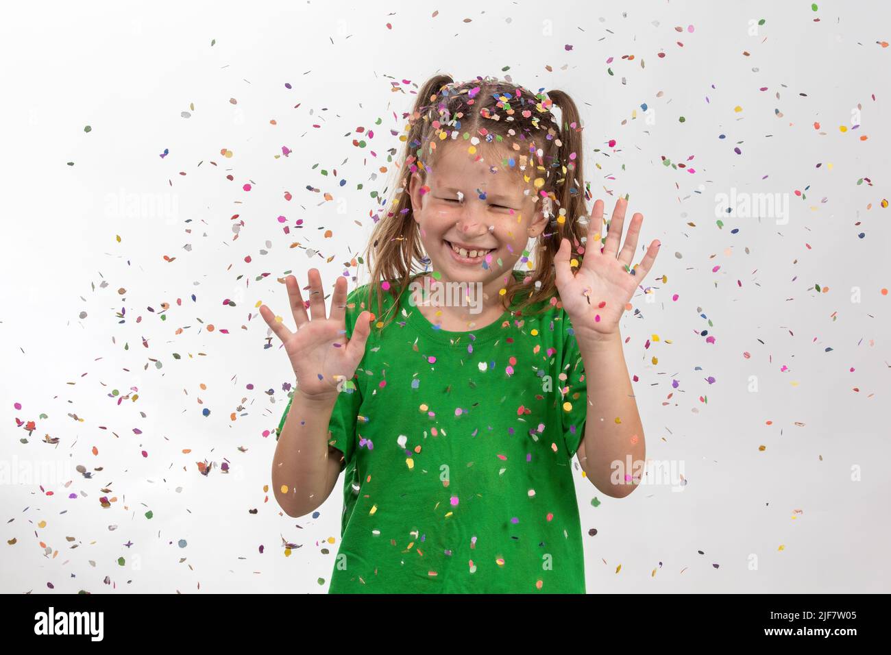 Confetti rain. Portrait of a child with multicolored tinsel and