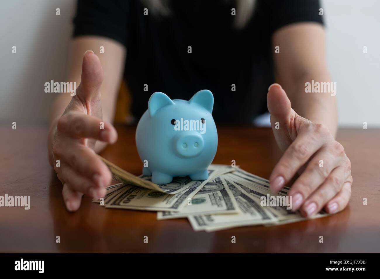 woman hand putting money bank note dollar into piggy for saving money ...