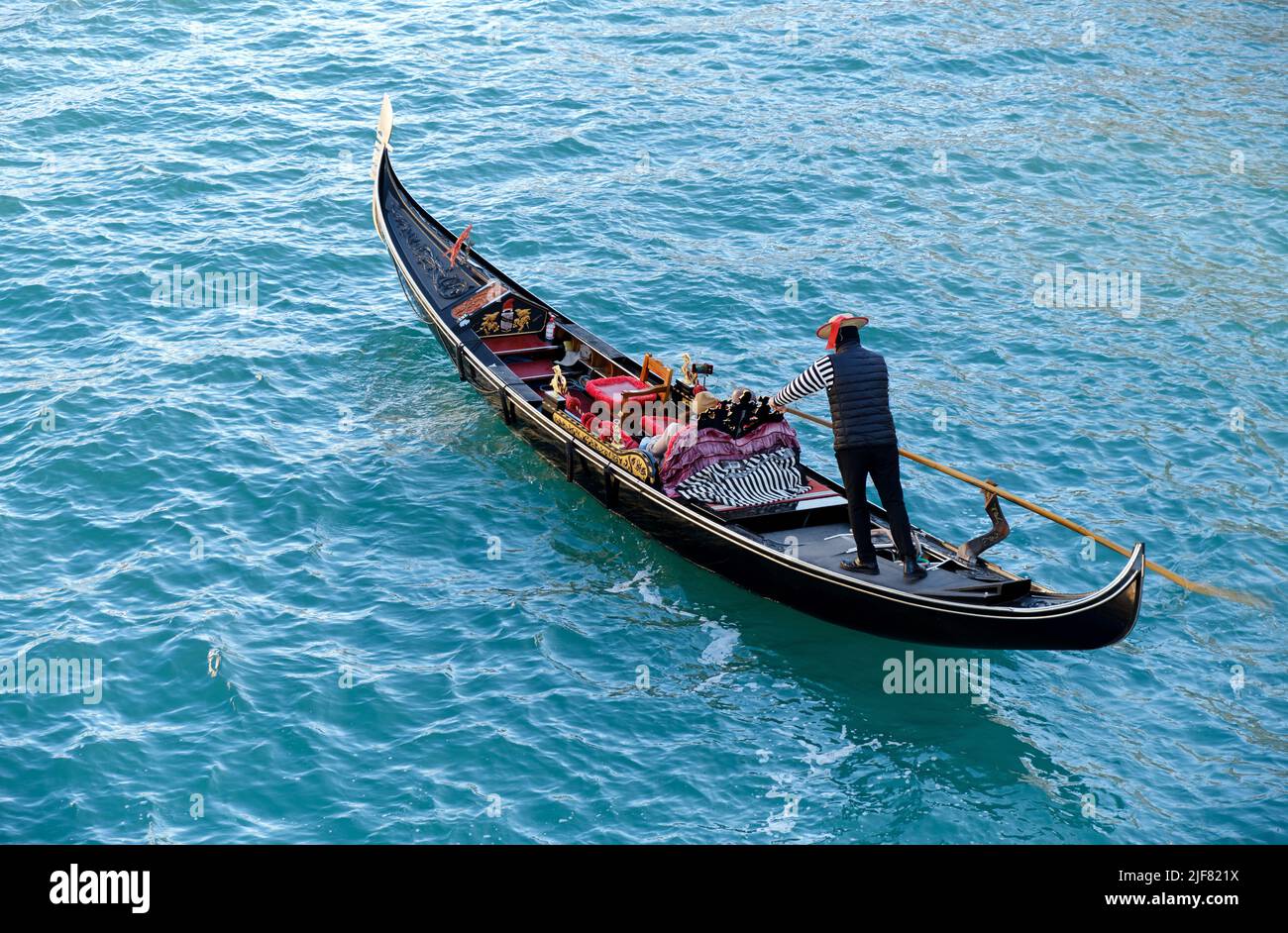 Venetian gondolier carries tourists on gondola in Grand Canal in Venice, Italy Stock Photo