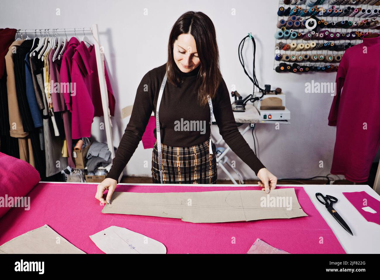 Pattern At Work Female fashion designer tailor making sewing patterns at workplace in ...