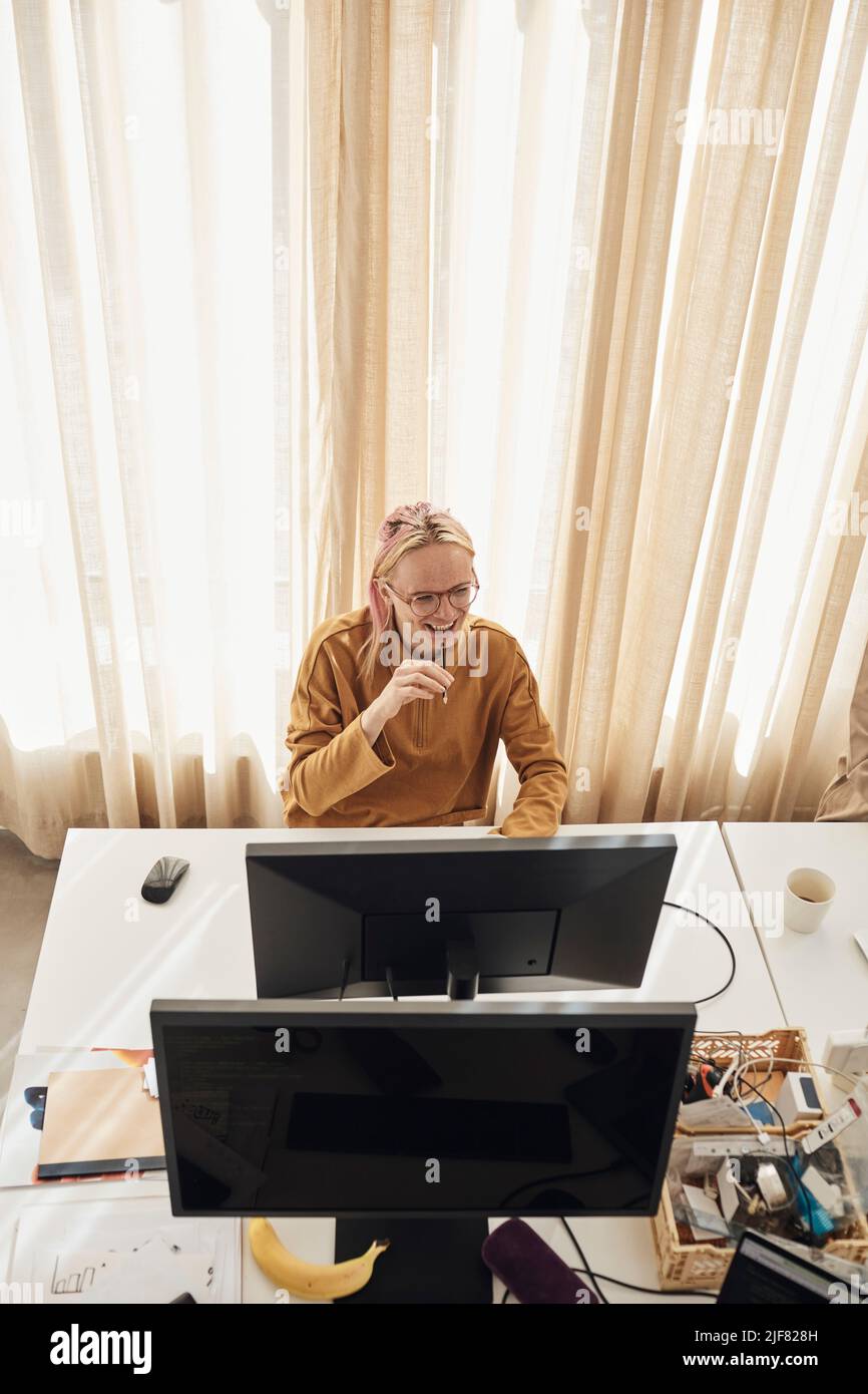 High angle view of smiling computer programmer sitting at desk in office Stock Photo
