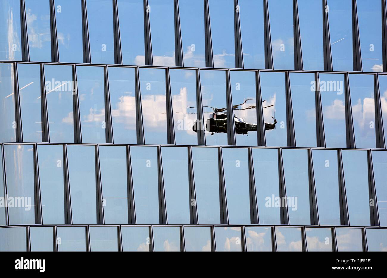 Reflected in office building windows, a Sikorsky VH-3D Sea King helicopter operated by Marine Helicopter Squadron One (HMX-1), the type used to transport the President as Marine One, flies along the Potomac River in Washington, U.S., June 30, 2022. REUTERS/Kevin Lamarque Stock Photo