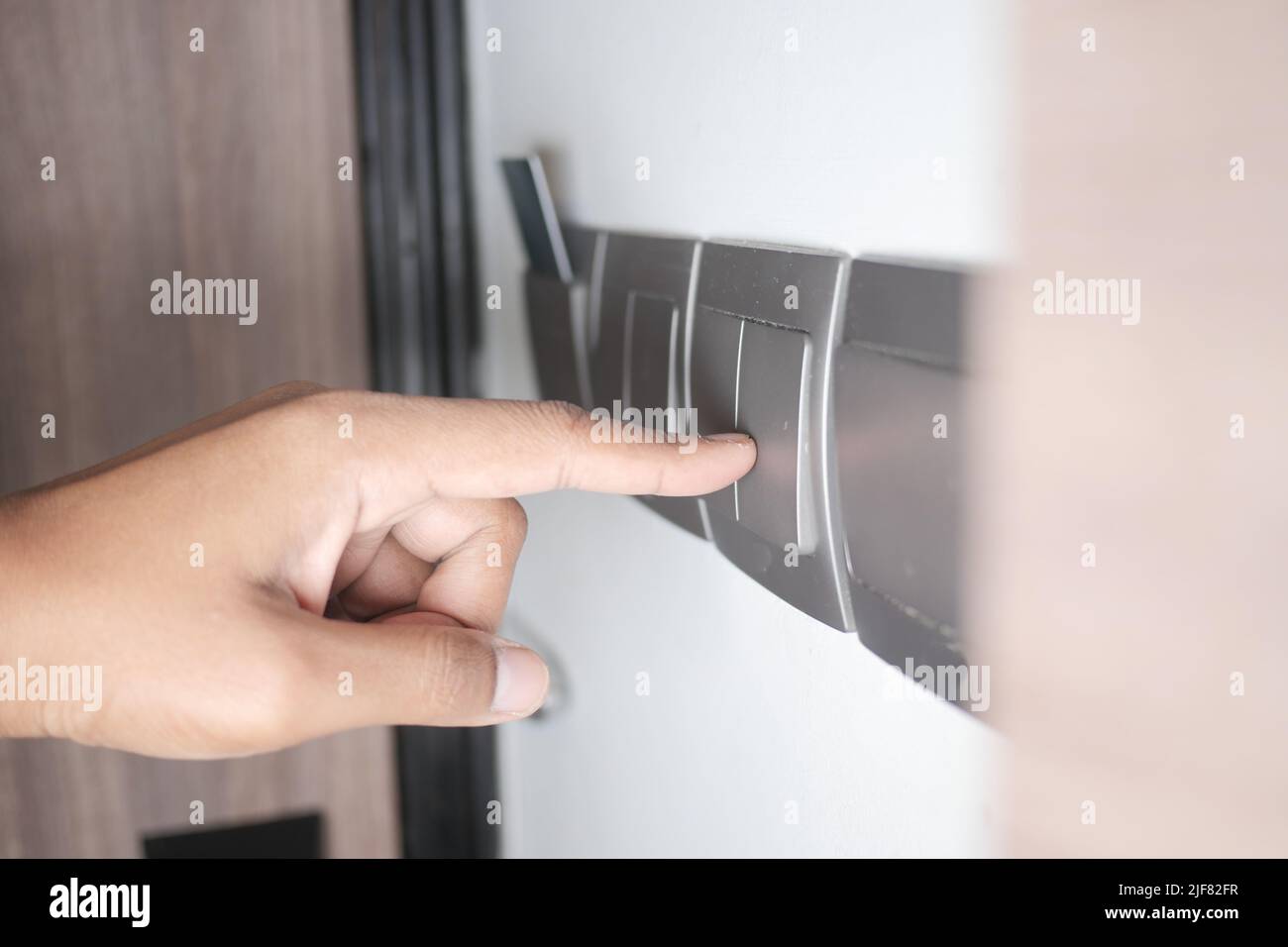 A finger turning on lighting switch Stock Photo - Alamy