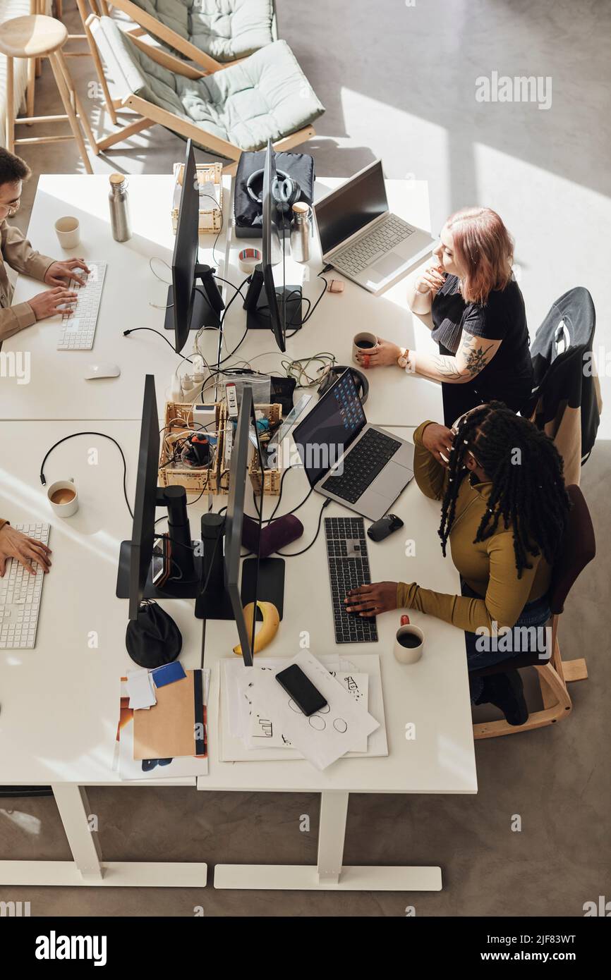 High angle view of computer programmers working while sitting at desk ...