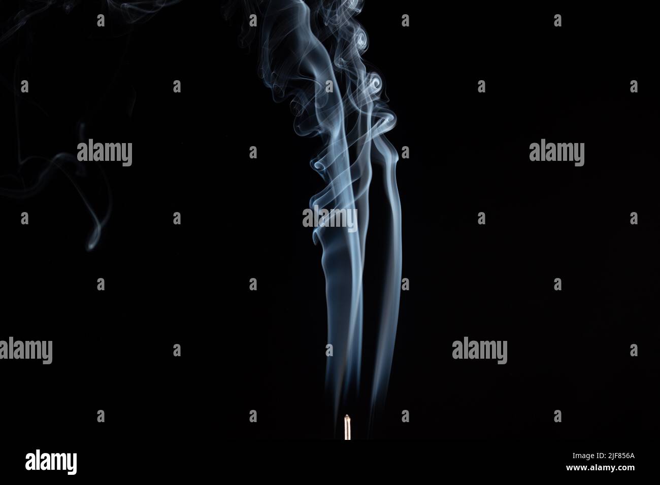 incense stick with smoke against black background Stock Photo