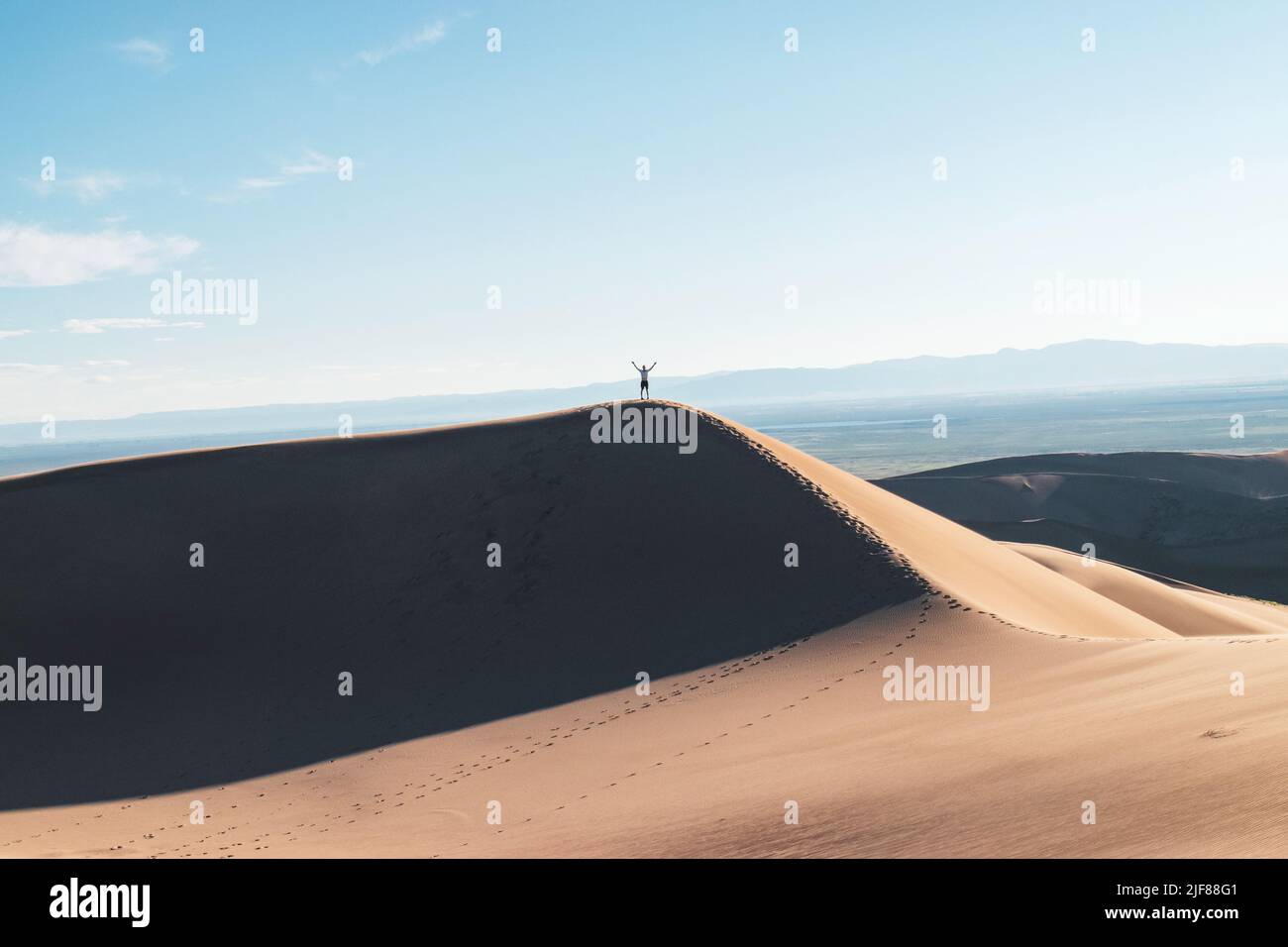 Celebrating climbing a dune in the desert Stock Photo - Alamy