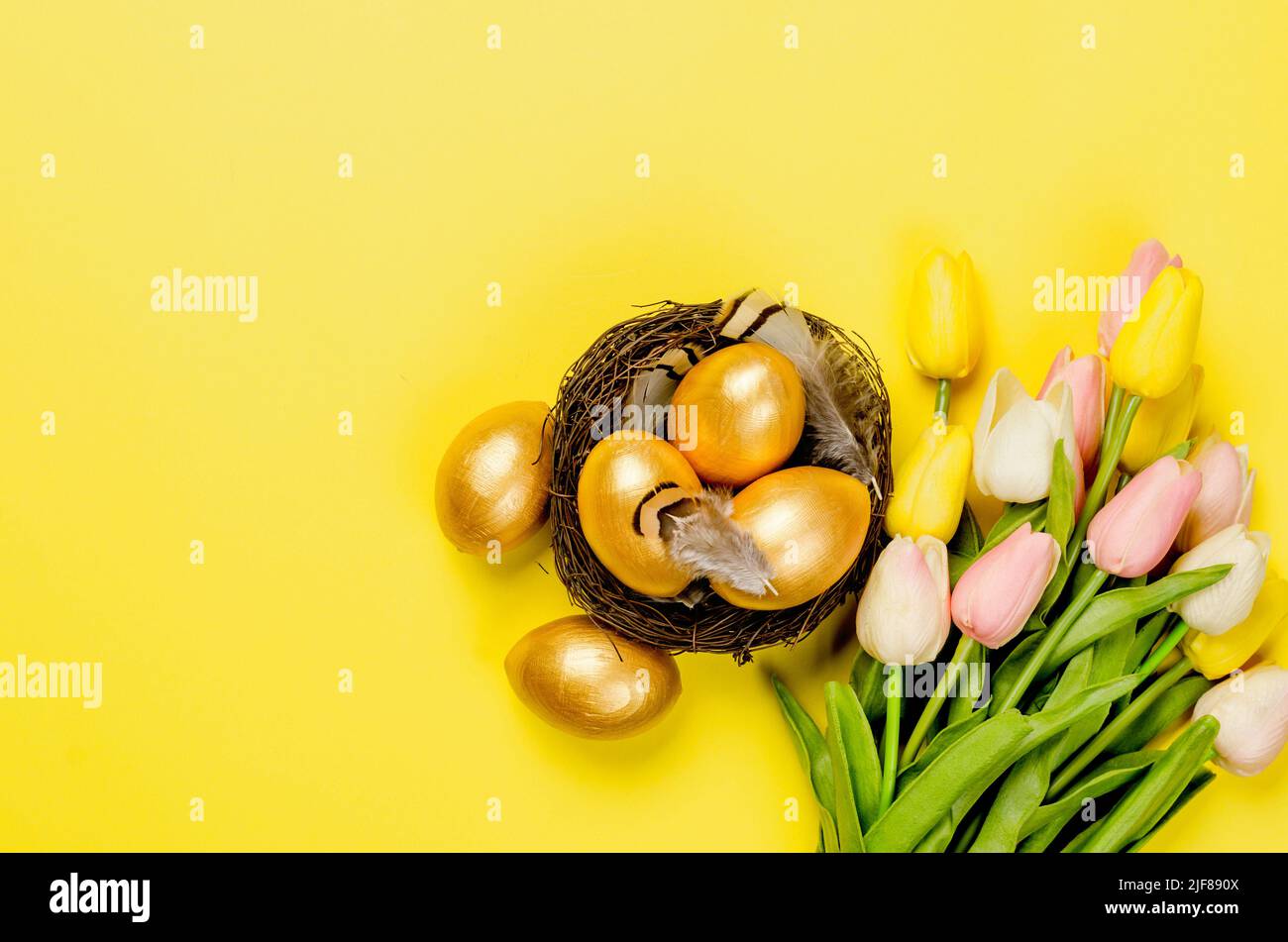 nest with gold decorative eggs and feathers in the nest on a gold ...
