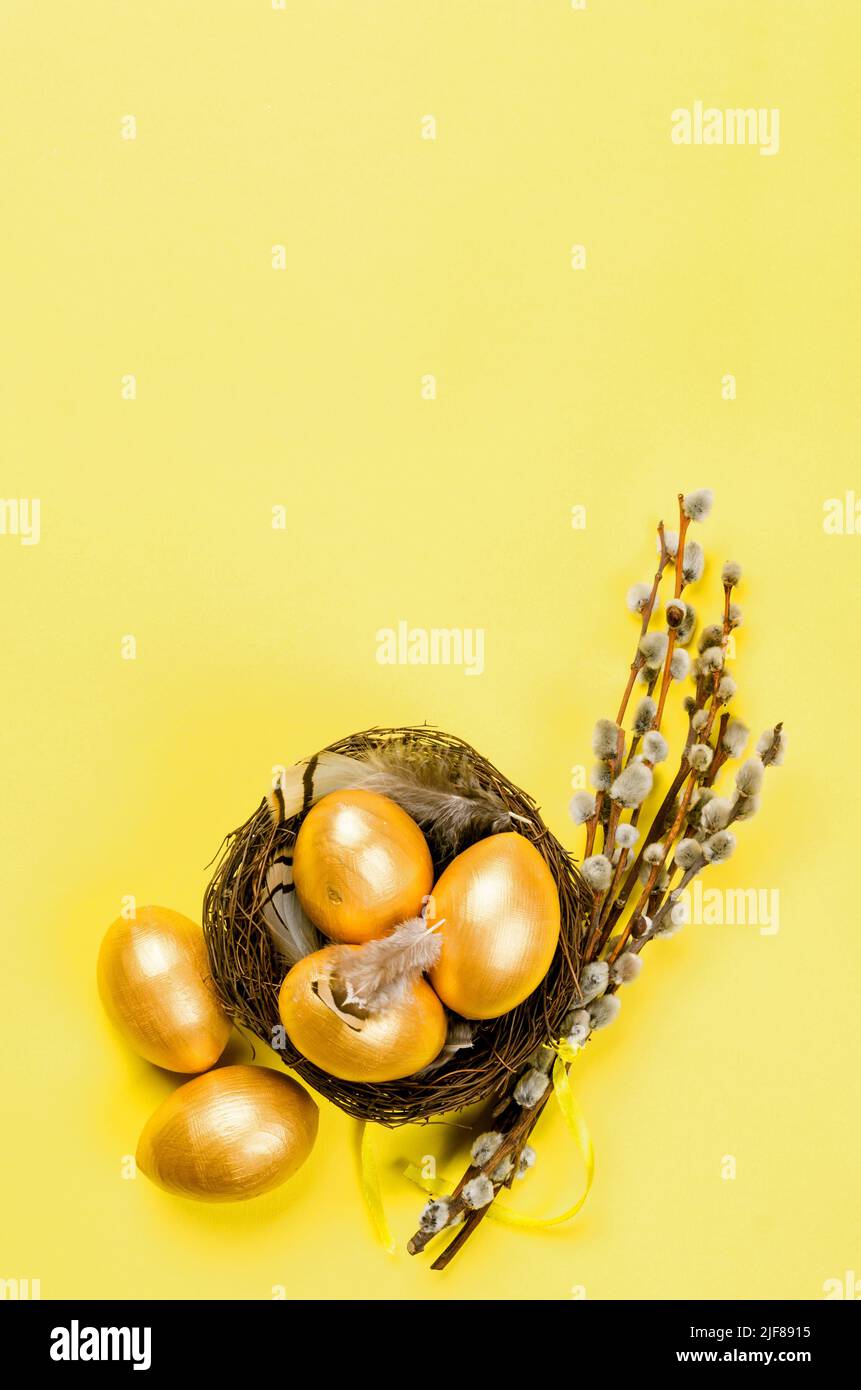 nest with gold decorative eggs and feathers in the nest on a gold ...