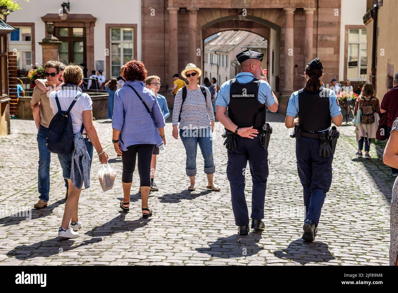 Police bike patrol in the streets of the touristic city of Riquewirh in Alsace | Patrouille de police a pied dans les rues de la cite medievale de Riq Stock Photo