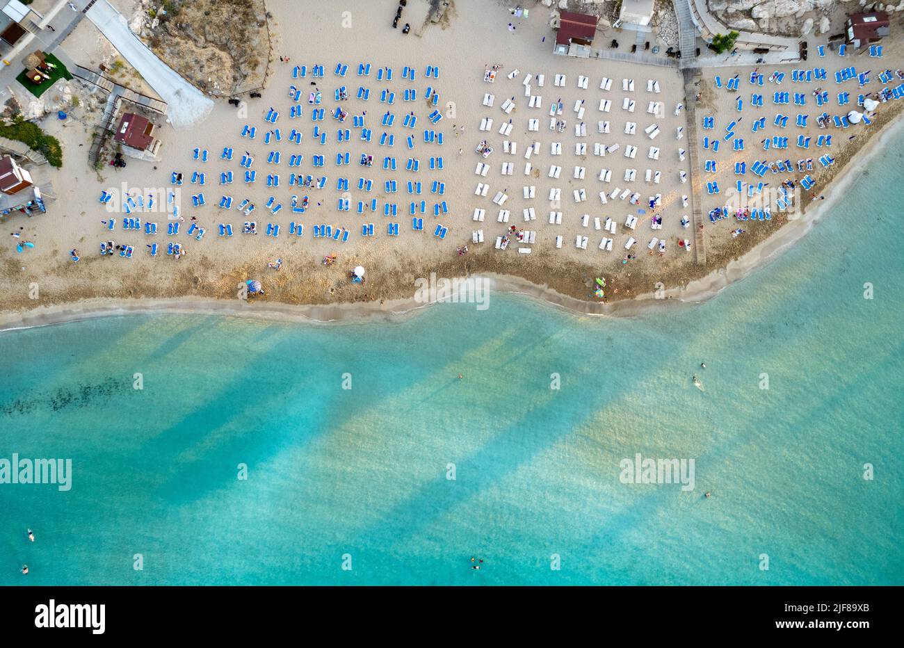 Beach umbrellas in a row at fig tree bay beach Protaras Cyprus. Summer vacations holiday resort. Stock Photo