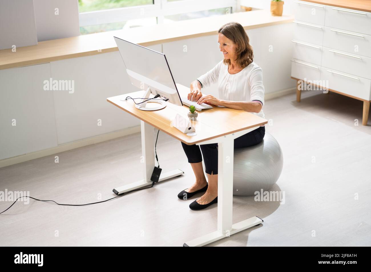 Correct Posture At Desk In Office Using Fitness Ball Stock Photo Alamy