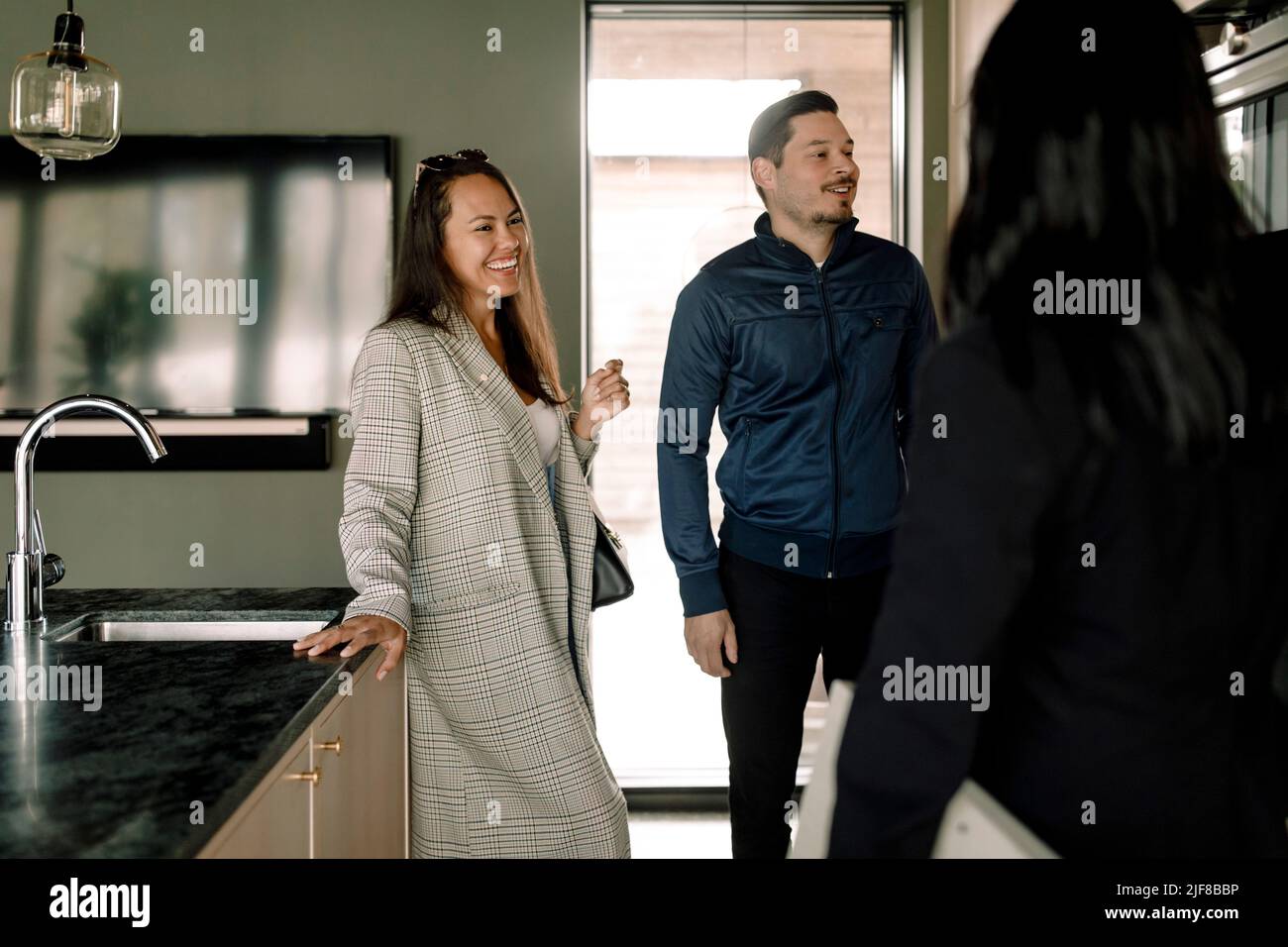 Couple talking with real estate agent at new home Stock Photo