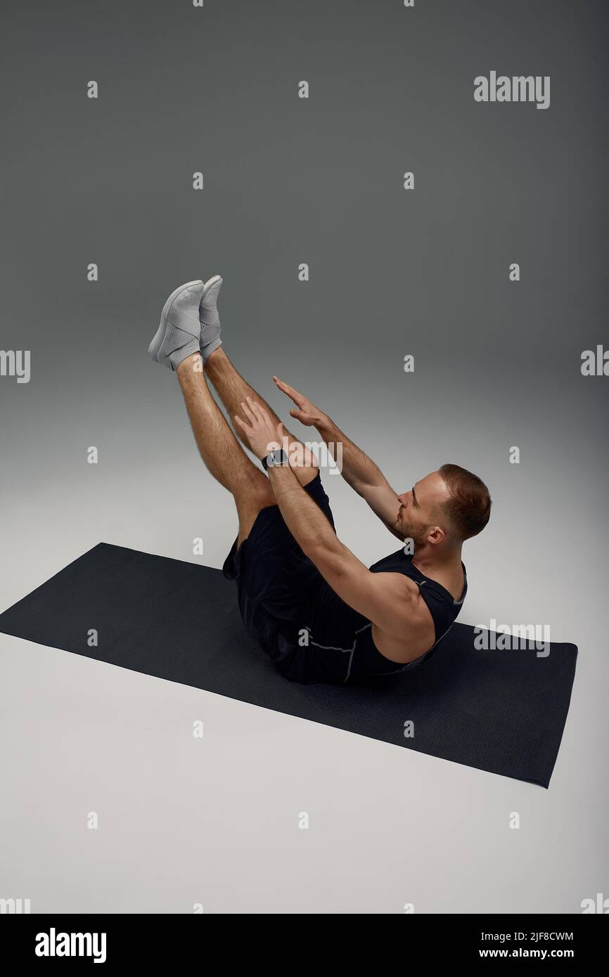 https://c8.alamy.com/comp/2JF8CWM/male-morning-workout-sporty-man-doing-sit-ups-abs-exercise-on-gymnastics-mat-training-and-working-out-fitness-lifestyle-motivation-stay-fit-concept-2JF8CWM.jpg