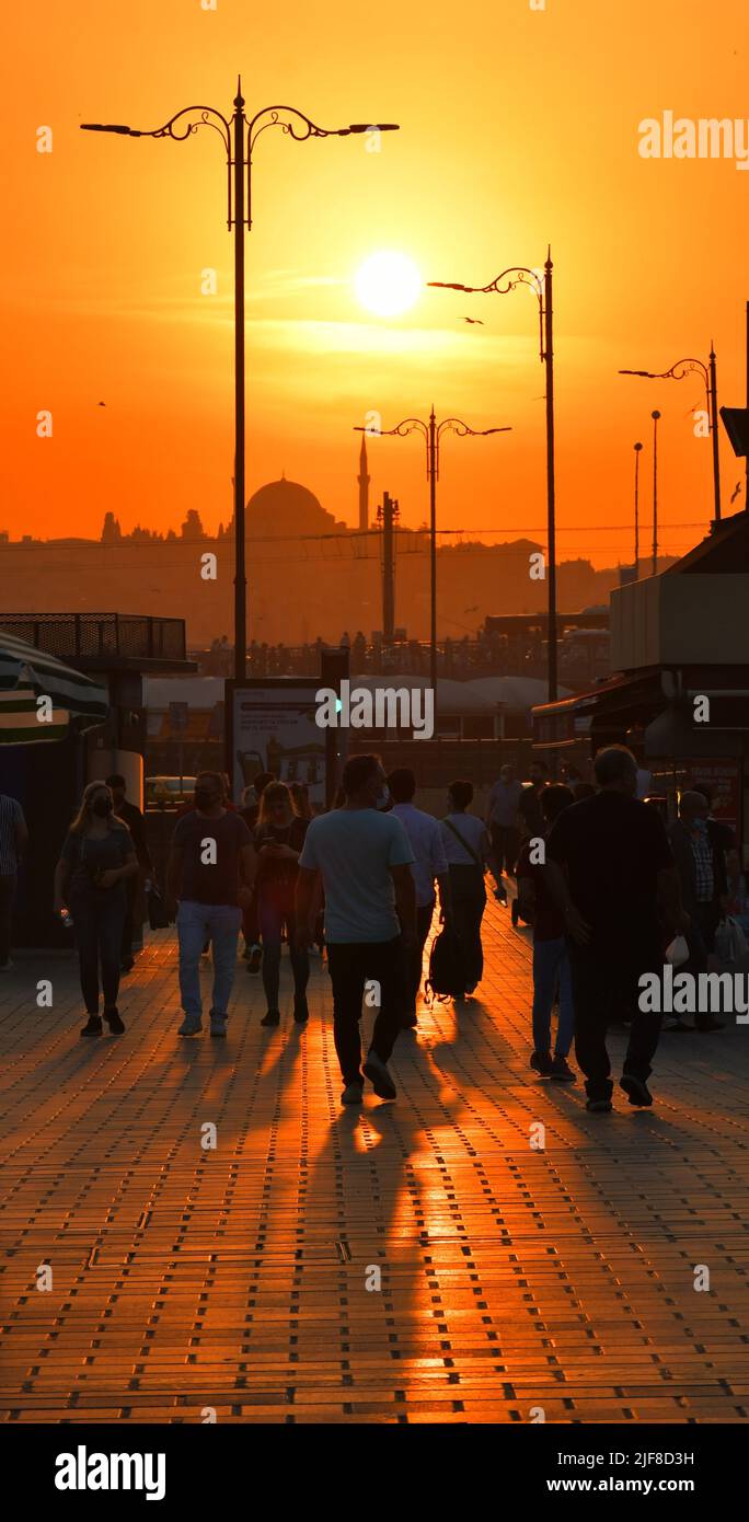 A unique sunset in the Bosphorus of Istanbul. A crowd of cities and mosques view the sun. Stock Photo
