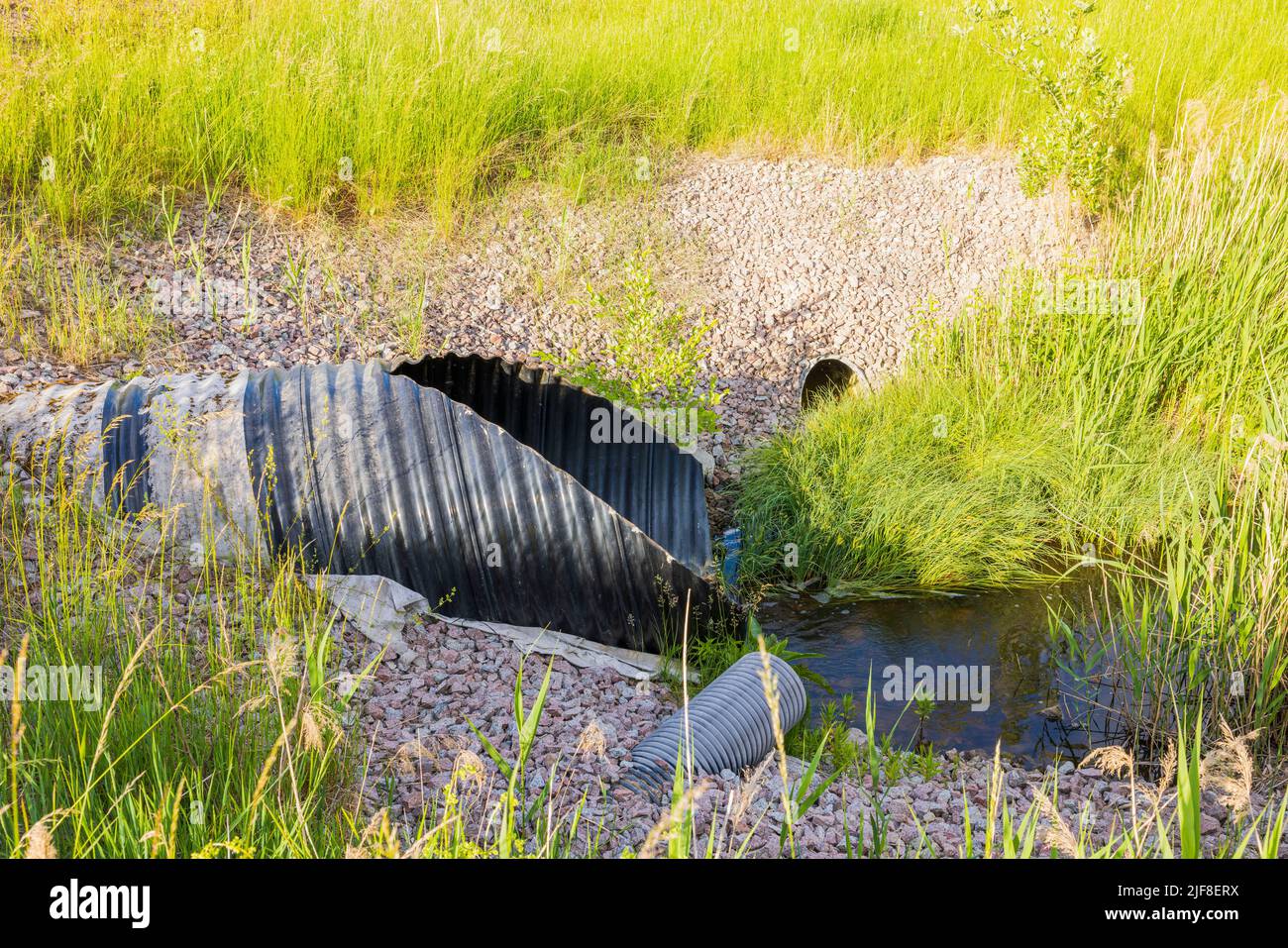 Close up view of drainage pipes coming out on side of road. Building ...