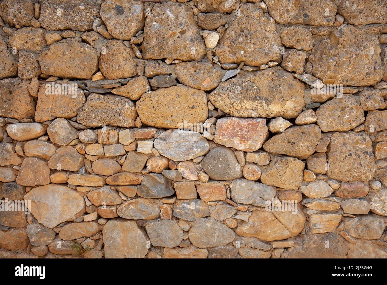An old stone wall made using different types of stone. Stone wall