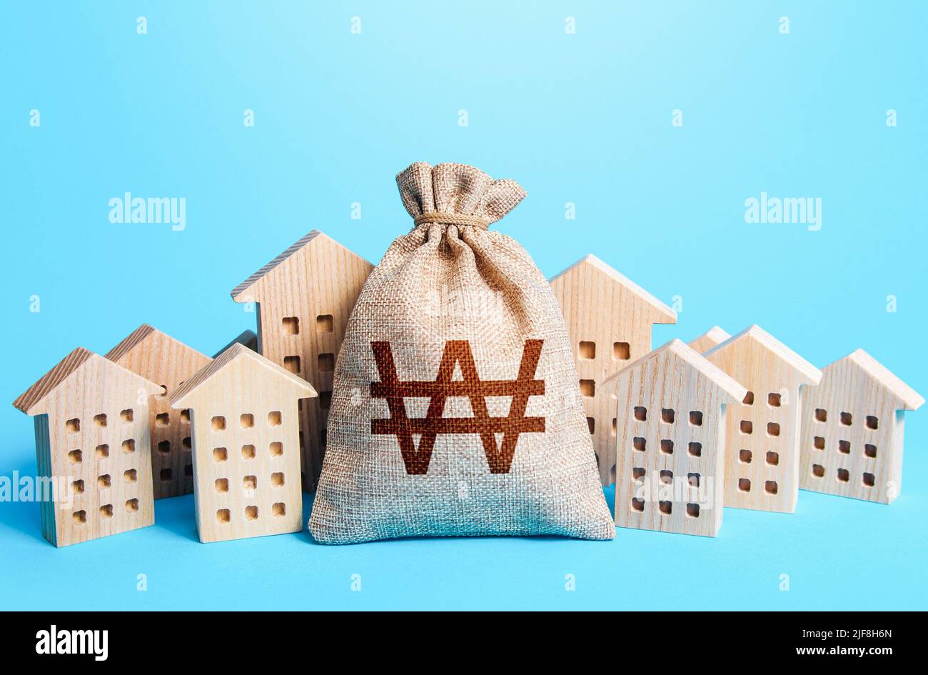 South korean won money bag among town houses figurines. Rich city