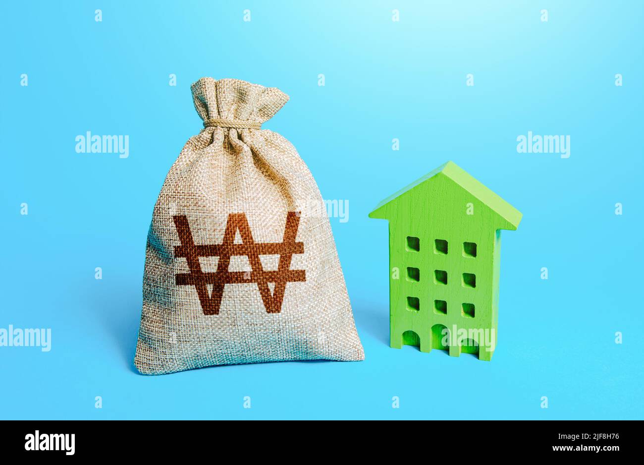 South korean won money bag and green Resident building. Investment in green technologies. Reduced emissions and energy efficiency. Reducing impact on Stock Photo