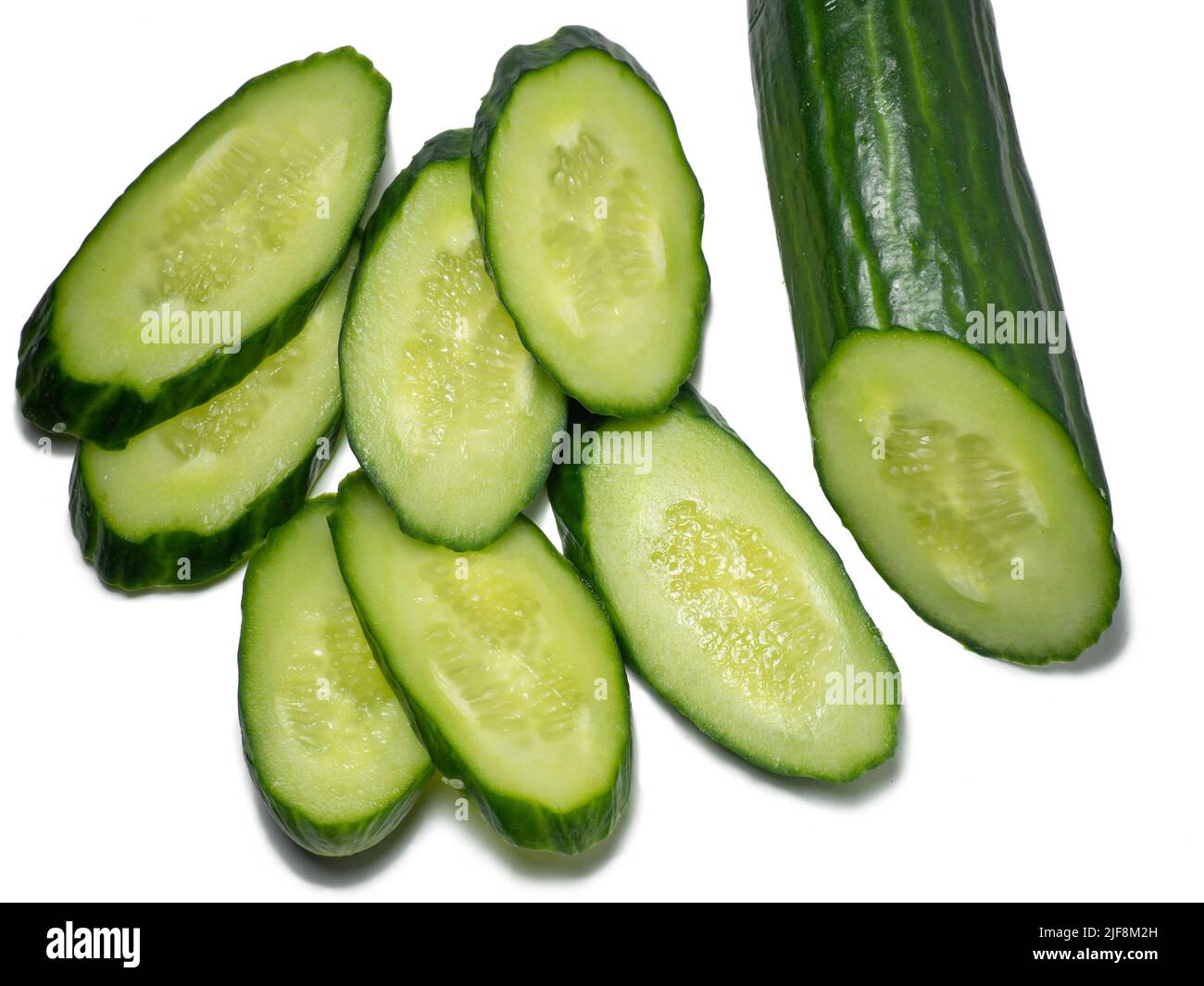 Smooth medium-sized cucumber on a white background. Cucumber slices, isolate. Sliced ​​vegetable. Vegetable isolate. Stock Photo