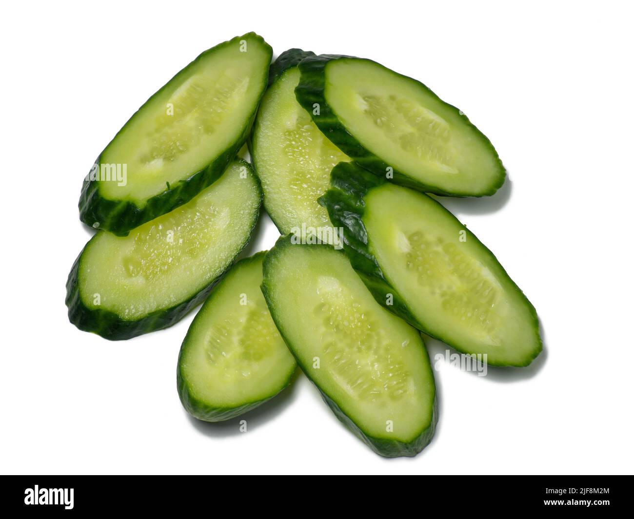 Smooth medium-sized cucumber on a white background. Cucumber slices, isolate. Sliced ​​vegetable. Vegetable isolate. Stock Photo