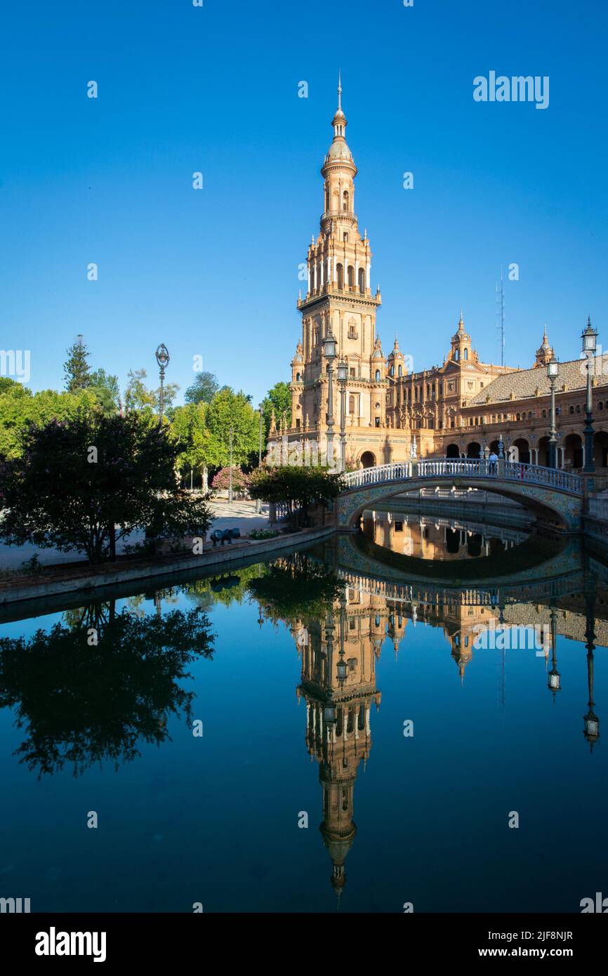 The north tower of the España square, reflected on the water during a summer morning, Sevilla Stock Photo