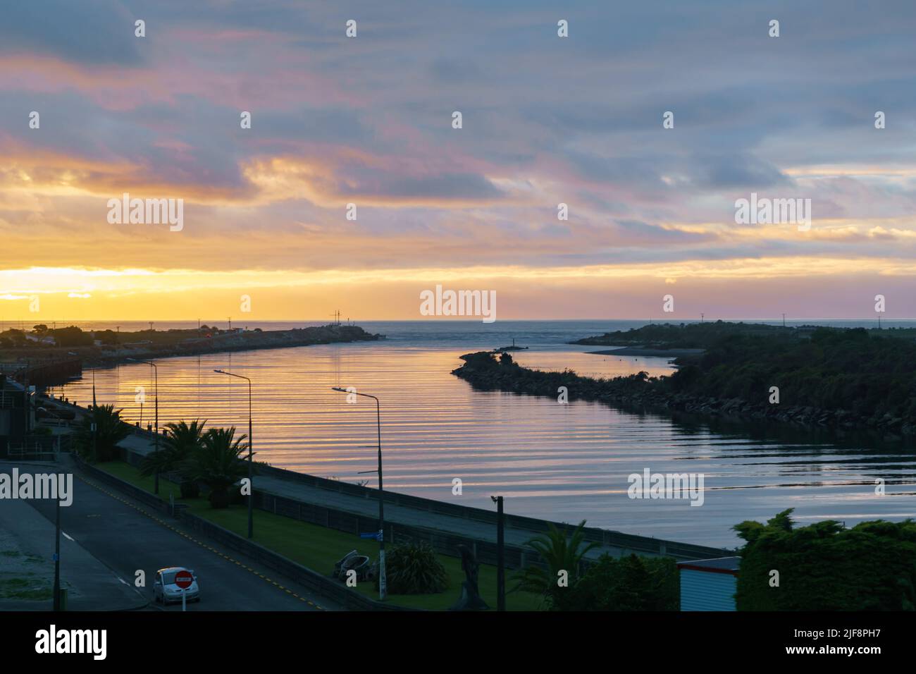 Dark cloudy sky in sunset colours over Grey River and West Coast at Greymouth New Zealand. Stock Photo