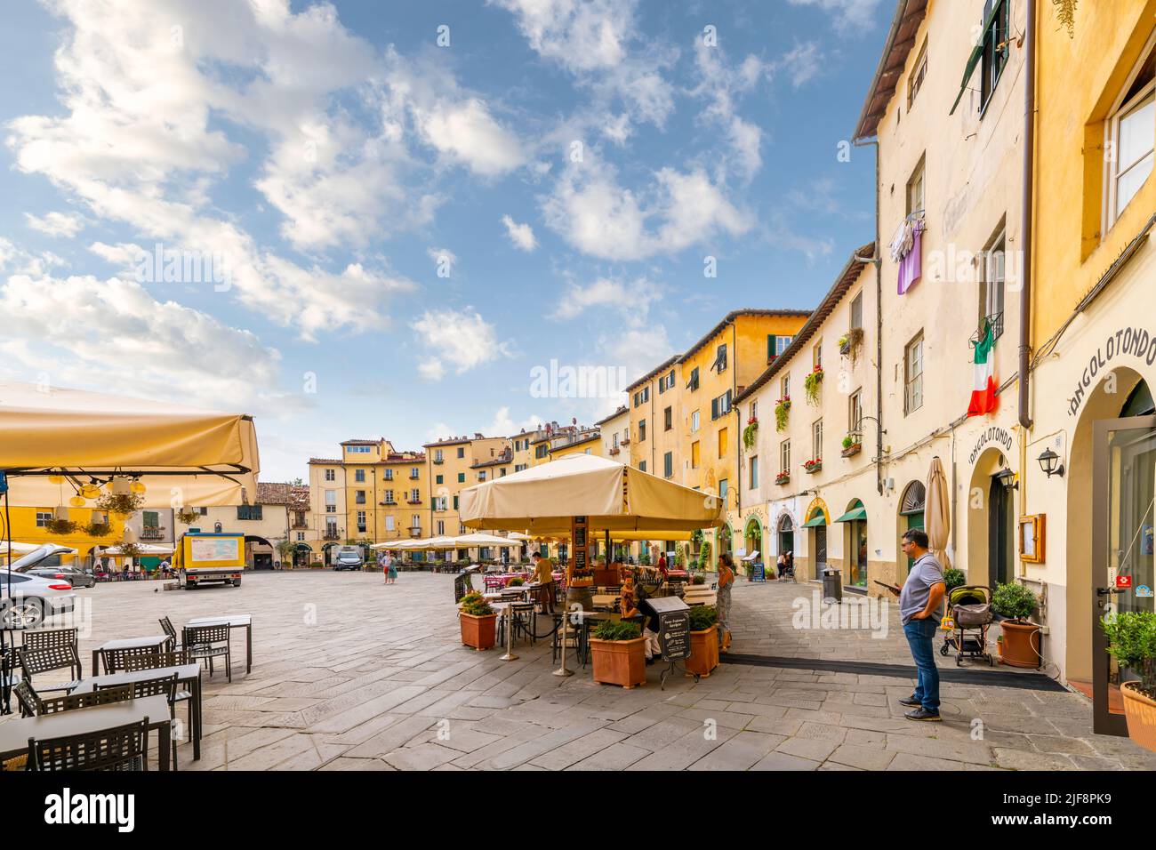 Sidewalk cafes inside the the Piazza del Anfiteatro, the ancient amphitheater in the Tuscan walled town of Lucca, Italy. Stock Photo