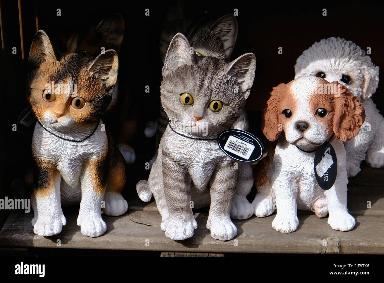 Resin cat and dog garden ornaments for sale in a garden centre Stock Photo