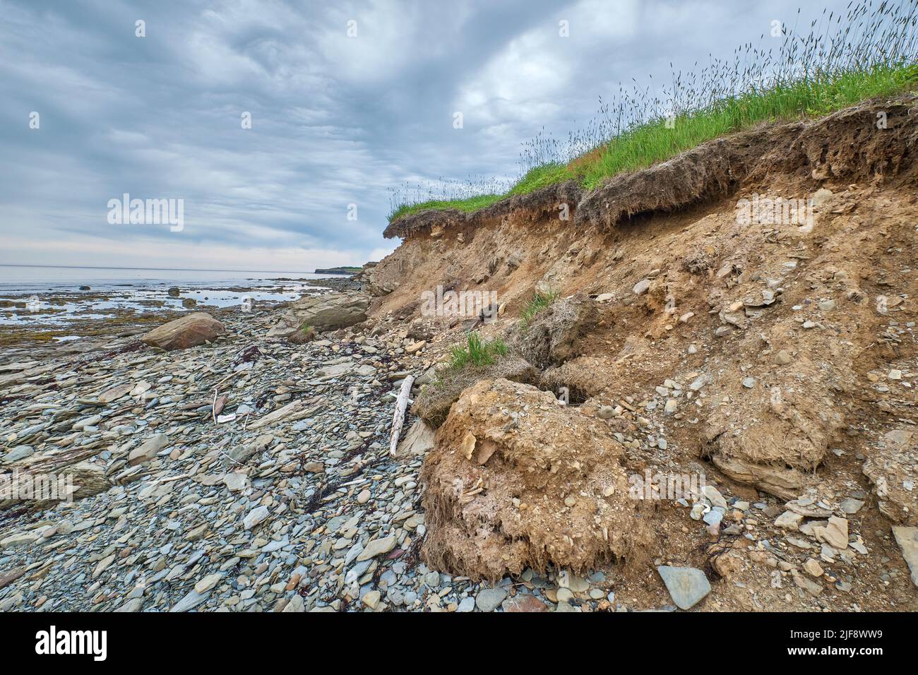 Photograph of a rocky ocean floor at low tide near the shore of Big Glace Bay Beach. Stock Photo
