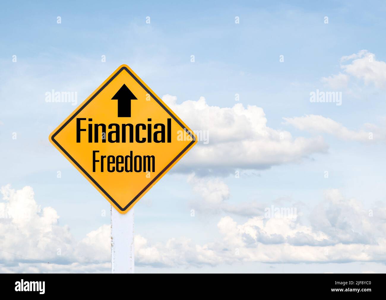 Yellow traffic sign text for financial freedom with blue sky background ...