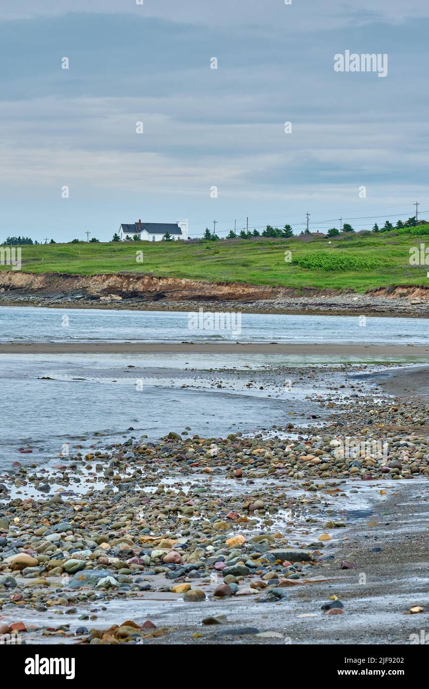 A small whire church typical of the region  sits atop a hill overlooking Glace bay Beach. Stock Photo