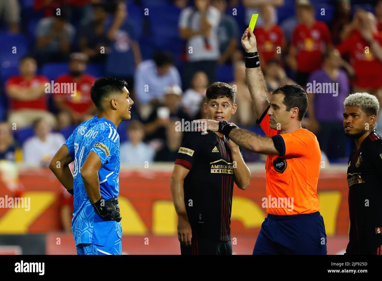 HARRISON, NJ - JUNE 30: Referee Alex Chilowicz issues a yellow card to  Atlanta United goalkeeper Rocco Ríos Novo (34) during the second half of  the Major League Soccer game between the