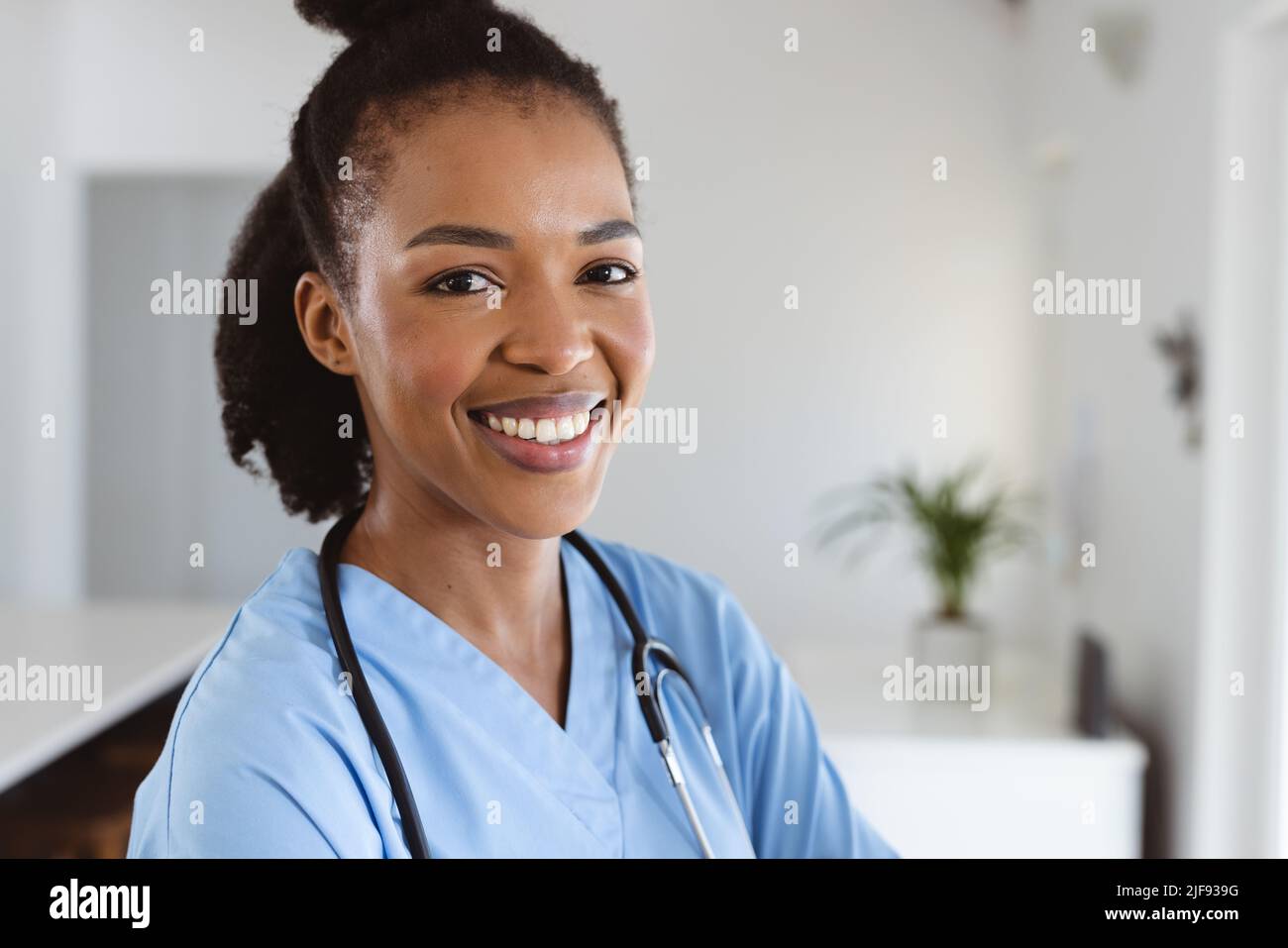 Portrait of smiling african american young female doctor with ...