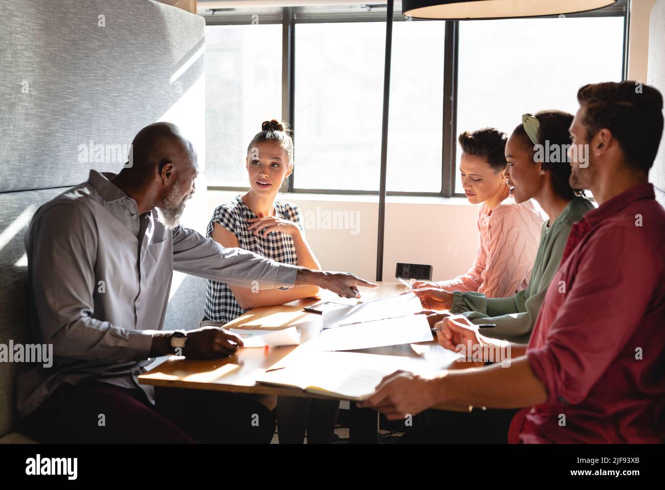 Multiracial business colleagues discussing business plan during meeting ...
