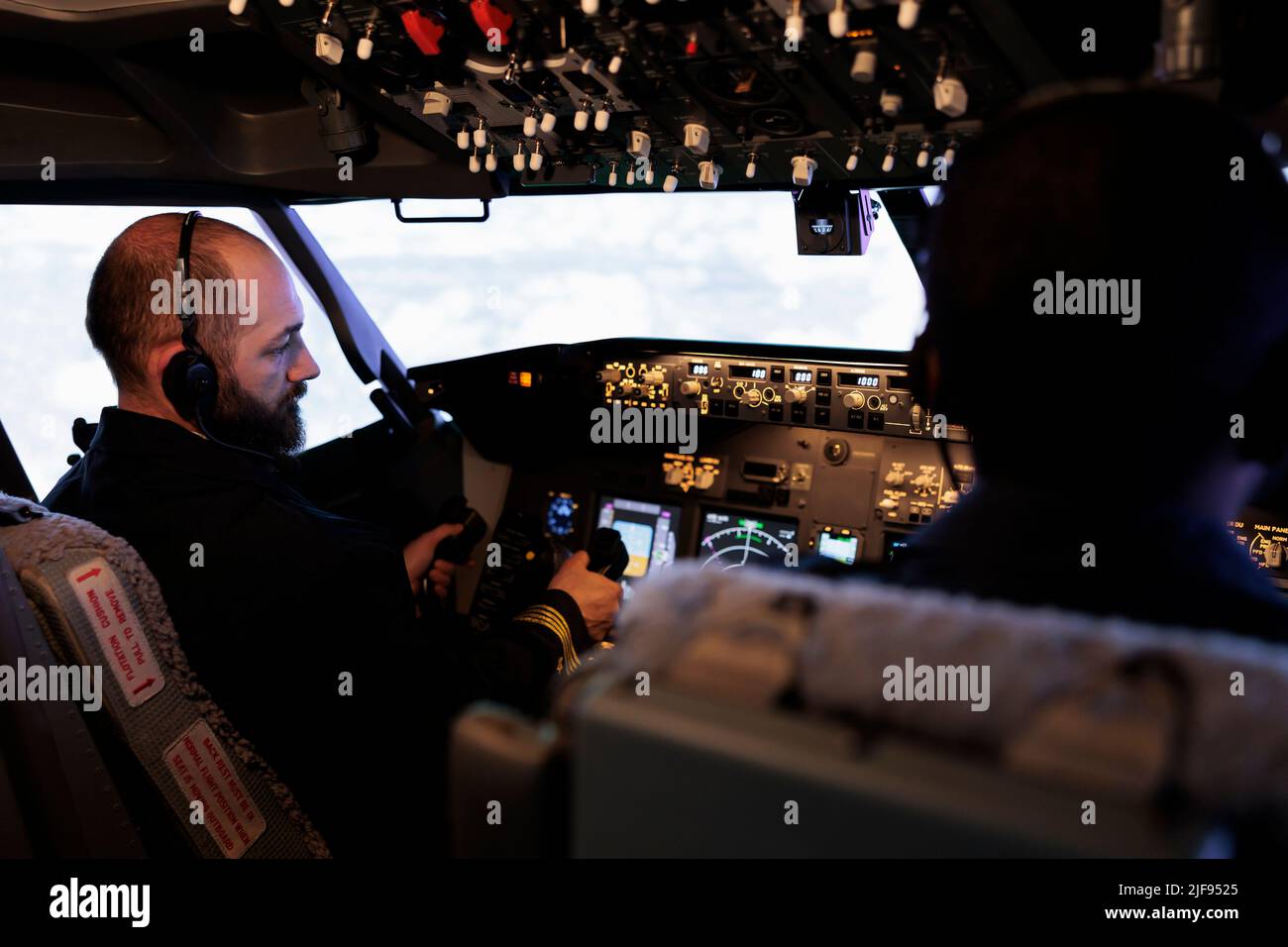 Plane pilot pushing buttons to start power on dashboard control, using ...