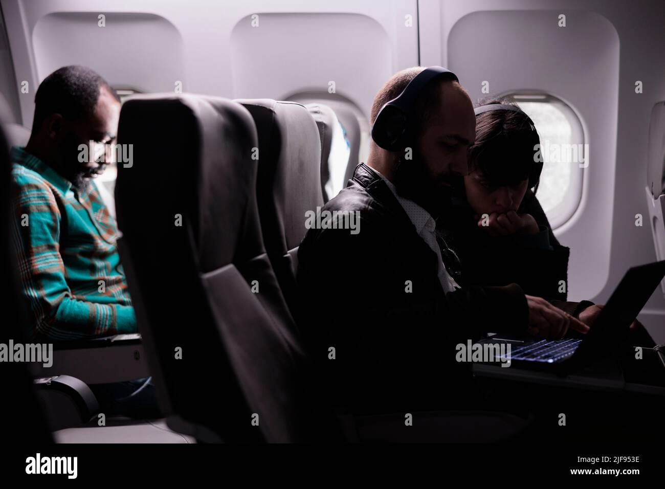 Diverse group of airplane passengers waiting to arrive at destination ...