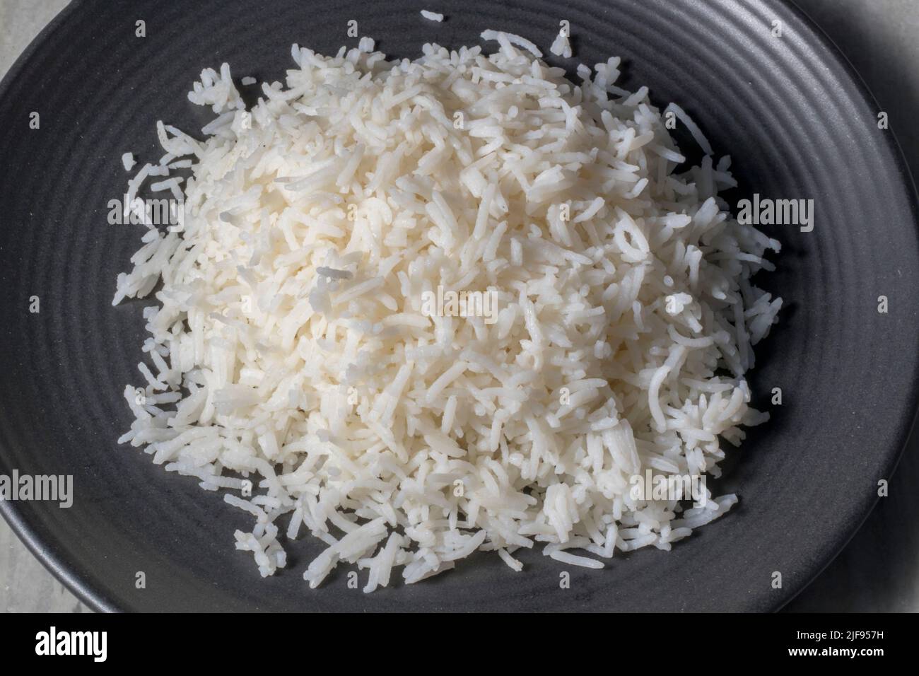 Basmati Rice on a black ceramic plate. Stock Photo