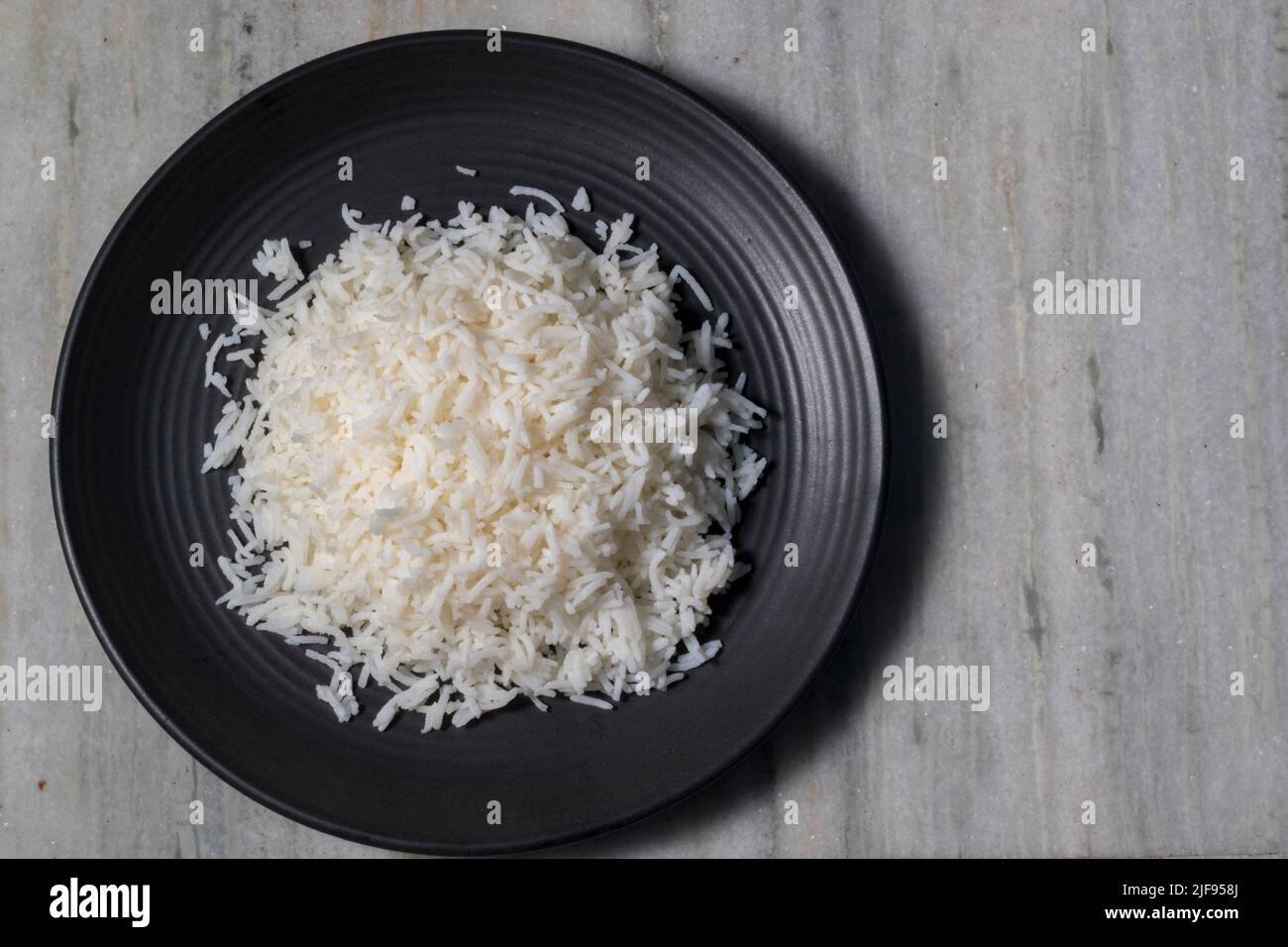 Basmati Rice on a black ceramic plate. Stock Photo