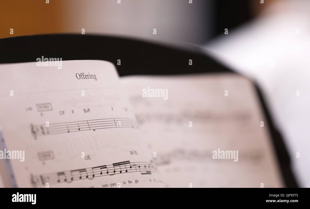 A close up view of the text or word 'Offering'. The christian hymn Offering musical score or sheet music with notes for the choir or musicians. Stock Photo