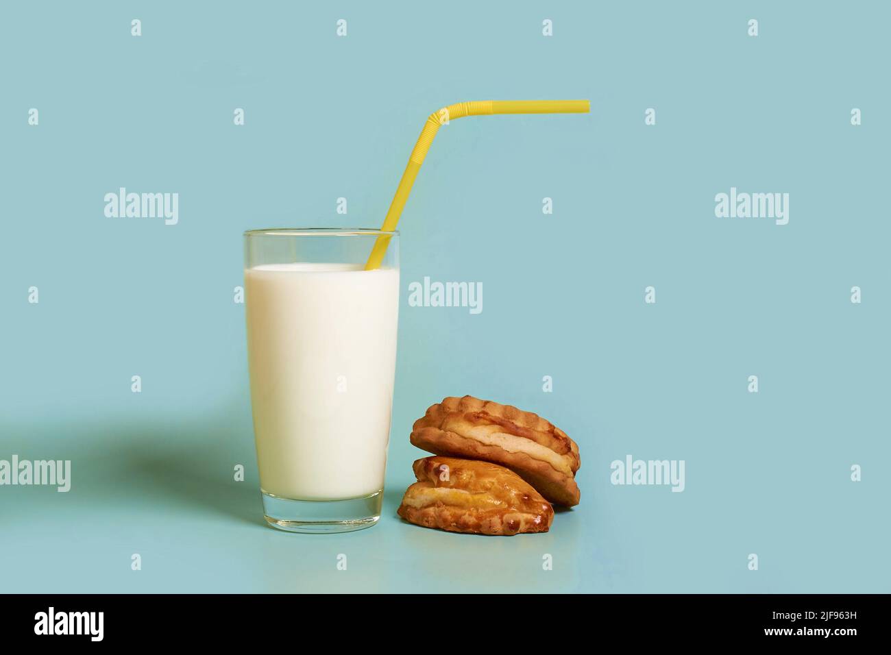 A glass of milk, plastic tube and cakes  Stock Photo